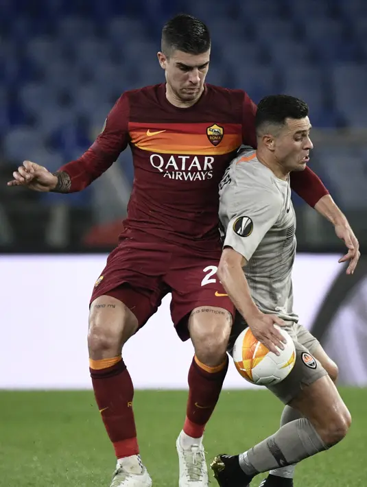 Bek AS Roma, Gianluca Mancini (kiri) berusaha merebut bola dari penyerang Shakhtar Donetsk, Junior Moraes pada leg pertama babak 16 besar Liga Europa di stadion Olimpiade, Italia, Jumat (12/3/2021). Laga leg kedua akan dimainkan di NSC Olimpiyskiy Stadium 18 Maret. (AFP/Filippo Monteforte)