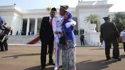 Seorang Perwira Remaja menangis sambil memeluk keluarganya usai dilantik Presiden Joko Widodo, di Istana Merdeka, Jakarta, Selasa (25/7). Dalam acara ini Jokowi melantik 729 orang Calon Perwira Remaja (Capaja) TNI-Polri. (Liputan6.com/Angga Yuniar)