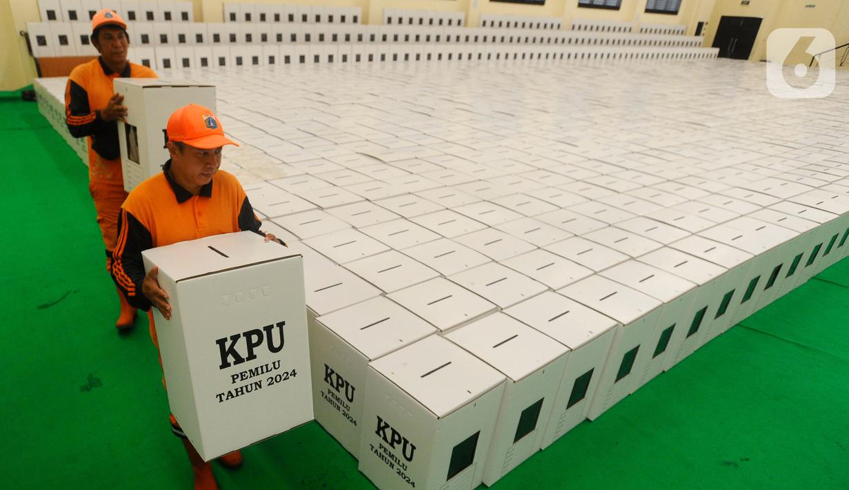 Petugas PPSU membawa kotak suara yang akan didistribusikan ke setiap kelurahan di Gudang Logistik PPK (Panitia pemungutan Kecamatan) di GOR Matraman, Jakarta Timur, Kamis (21/12/2023). (merdeka.com/Arie Basuki)
