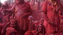 Sejumlah peserta yang tubuhnya berlumuran bubuk merah beristirahat saat mengikuti perayaan Lathmar Holi di Barsana, Uttar Pradesh, India (6/3). (AFP Photo/STR)