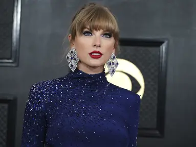 Taylor Swift tiba menghadiri ajang Grammy Awards 2023 di Crypto.com Arena, Los Angeles, AS, Senin (6/2/2023) pagi waktu Indonesia. Penyanyi berusia 33 tahun itu tampil memesona dengan gaun crop top lengan panjang warna biru dihiasi aksen glitter dari Roberto Cavalli. (Photo by Jordan Strauss/Invision/AP)