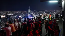 Gambar pada 14 Februari 2019, para turis menikmati dan mengambil gambar pemandangan cakrawala kota dari dek observasi Menara Kuala Lumpur di ibu kota Malaysia. Di sini pengunjung bisa mengamati segala penjuru kota Kuala Lumpur. (Mohd RASFAN / AFP)