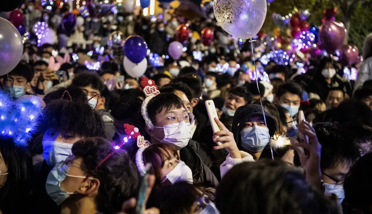 Orang-orang menghadiri  hitung mundur di Wuhan, provinsi Hubei, China (1/1/2021). Beberapa warga Wuhan mengatakan mereka berhati-hati, tetapi sebagaian tidak khawatir tertular Covid-19. (AFP/Noel Celis)