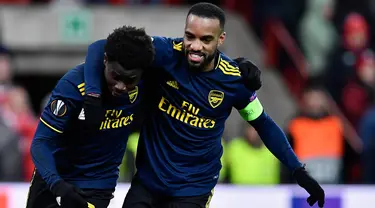 Pemain Arsenal Bukayo Saka (kiri) merayakan golnya ke gawang Standard Liege bersama Alexandre Lacazette pada pertandingan Grup F Liga Europa di Stadion Maurice Dufrasne, Liege, Belgia, Kamis (12/12/2019). Arsenal juara grup setelah menahan Standar Liege 2-2. (JOHN THYS/AFP)