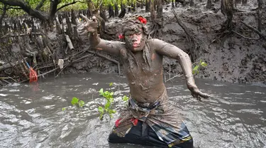 Seorang pria Bali mengambil bagian dalam tradisi mandi lumpur, yang dikenal sebagai Mebuug-buugan, di desa Kedonganan, Bali, pada 12 Maret 2024. (SONNY TUMBELAKA/AFP)