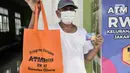 Warga menunjukkan kartu ATM dan paket bantuan beras di Kantor RW 02, Kelurahan Cilincing, Jakarta Utara, Rabu (17/3/2021).  Pembuatan ATM Beras secara mandiri sebagai program ketahanan pangan di masa pandemi Covid-19. (merdeka.com/Iqbal S. Nugroho)