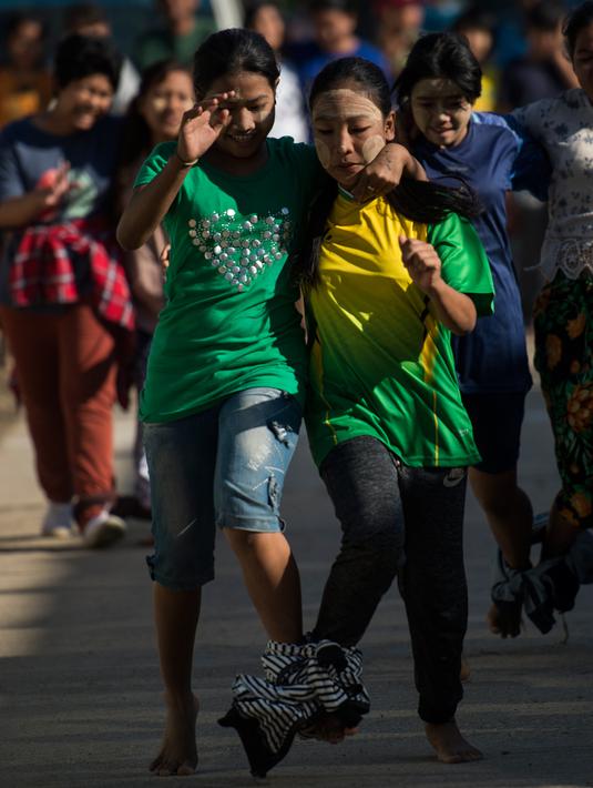 Sejumlah wanita memainkan permainan lari dengan kaki diikat untuk menandai Hari Kemerdekaan ke-71 Myanmar di pinggiran Yangon( 4/1). Negara ini merayakan peringatan ke-71 deklarasi kemerdekaannya dari pemerintahan kolonial Inggris. (AFP Photo/Ye Aung Thu)