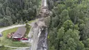 Para kru mulai memperbaiki bagian jalan raya 170 yang tersapu air di Riviere-Eternite, Quebec, Minggu, 2 Juli 2023. (Jacques Boissinot/The Canadian Press via AP)