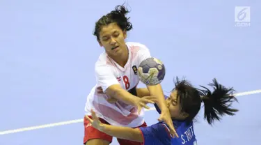 Pemain bola tangan putri Indonesia, M Shinta Hidayatuzzaroh (kiri) berebut bola dengan bek Thailand, Thitima Sriratbuaphan pada babak penyisihan grup B Asian Games 2018 di Jakarta, Kamis (16/8). Indonesia kalah 16-34. (Liputan6.com/Helmi Fithriansyah)