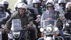 Presiden Brasil Jair Bolsonaro (kiri) melakukan tur sepeda motor dengan para pendukung di Brasilia, di tengah pandemi virus corona pada Minggu (9/5/2021). Bolsonaro memimpin ratusan pengendara motor melakukan perjalanan mengelilingi ibu kota Brasil untuk memperingati Hari Ibu (AP Photo/Eraldo Peres)
