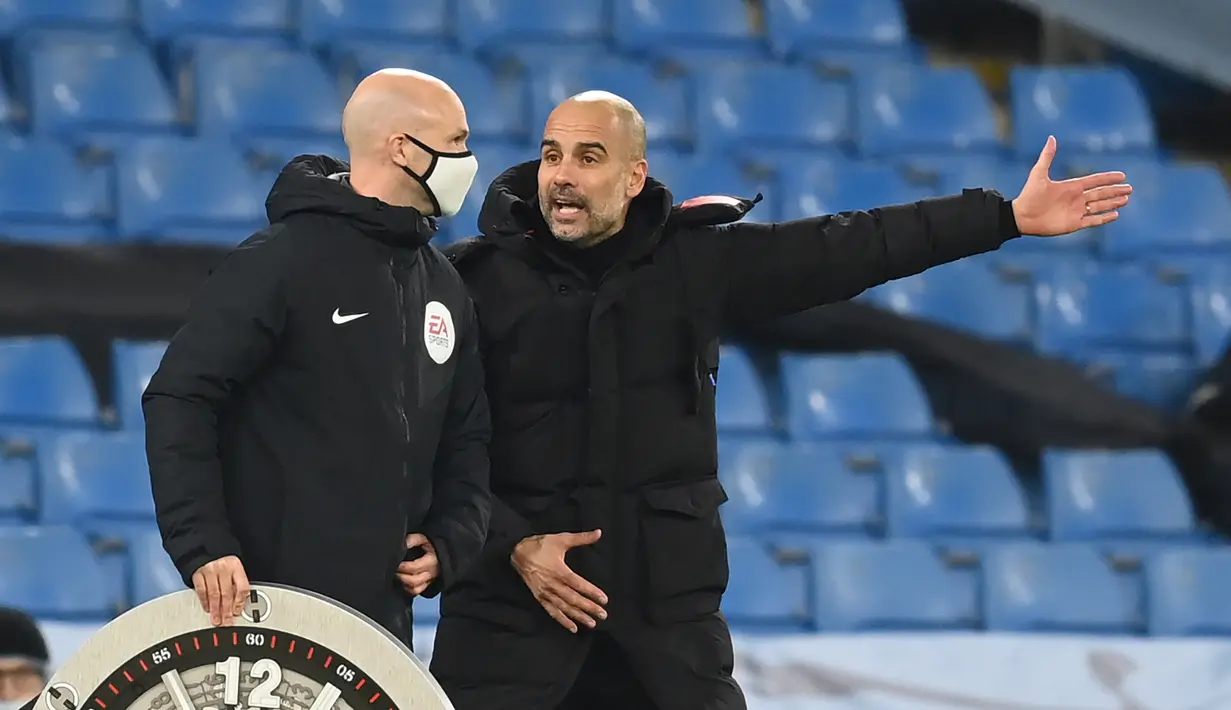 Pelatih Manchester City, Pep Guardiola, berbicara kepada ofisial wasit saat pertandingan melawan West Brom pada laga lanjutan Liga Inggris di Etihad Stadium, Rabu (16/12/2020). Pep Guardiola melakukan protes karena durasi injury time yang dianggap sedikit. (AFP/Clive Brunskill/pool)