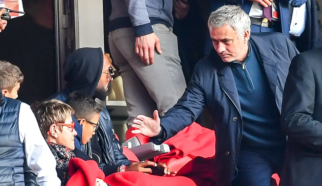 Mantan pelatih Manchester United Jose Mourinho (kanan) berjabat tangan dengan mantan pesepak bola Nicolas Anelka saat nonton Ligue 1 antara Lille melawan Montpellier di Stadion Pierre Mauroy, Villeneuve-d'Ascq, Prancis, Minggu (17/2).(Philippe HUGUEN/AFP)