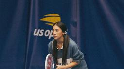 Anya Geraldine saat berkesempatan turun langsung ke lapangan turnamen tenis US Open 2022. Pemilik nama lengkap Nur Amalina Hayati ini tampil memakai kaus oversize, short pants, dan sneakers  dengan rambut dikuncir dua. Penampilan Anya ini sangat cantik natural. (Instagram/anyageraldine)