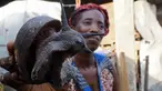 Penjual memperlihatkan sebuah siput yang dijualnya di sebuah pasar di Abidjan, Pantai Gading, Kamis (16/3). Siput menjadi salah satu hewan yang biasa dikonsumsi di daerah tersebut. (AFP PHOTO / ISSOUF Sanogo)