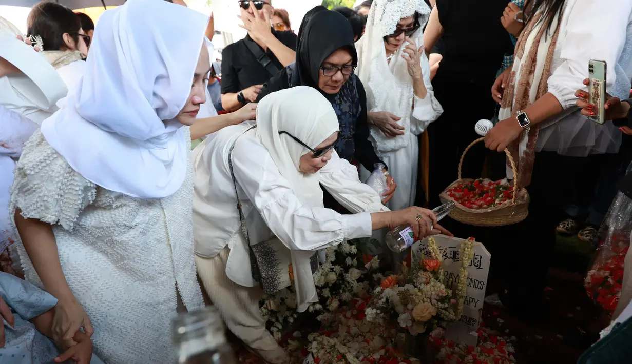 Usai jenazah dimakamkan, Dewi Yull ikut menabur bunga dan menyiram air mawar ke makam Ray Sahetapy sambil melantunkan doa. (KapanLagi.com/Budy Santoso)
