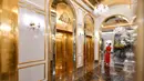 Seorang pegawai berdiri di dekat lift hotel Dolce Hanoi Golden Lake yang baru saja diresmikan di Hanoi, Vietnam pada Kamis (2/7/2020). Hotel tersebut merupakan hotel berlapiskan emas 24 karat pertama di dunia. (Manan VATSYAYANA / AFP)