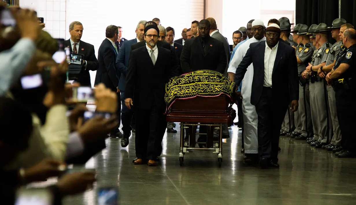 Pengusung jenazah mengawal peti mati mendiang Muhammad Ali yang hendak disalatkan di Louisville, Kentucky, AS, Kamis (9/6). Jenazah Muhammad Ali terbaring di peti mati yang dilapisi kain bertuliskan bahasa Arab berwarna hitam dan emas. (JIM WATSON/AFP)
