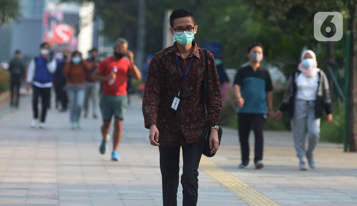 Seorang pria yang mengenakan baju batik berjalan di kawasan Thamrin Sudirman, Jakarta, Jumat (2/10/2020). Pada Hari Batik Nasional yang berlangsung di tengah pandemi COVID-19, sebagian masyarakat terlihat mengenakan baju dan masker dengan motif batik. (merdeka.com/Imam Buhori)