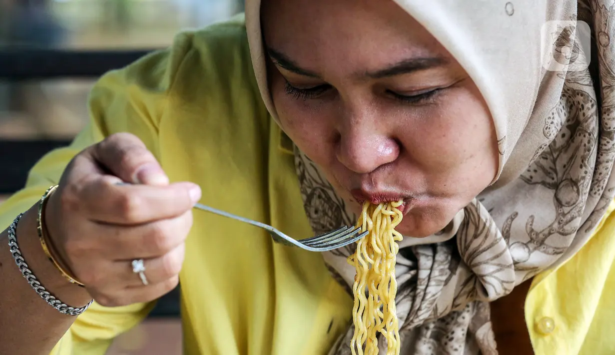 Warga menikmati mie instan di warung kopi (Warkop), Jakarta, Kamis (11/8/2022). Perang yang terjadi antara Rusia dan Ukraina berdampak pada naiknya harga mi instan. (Liputan6.com/Johan Tallo)