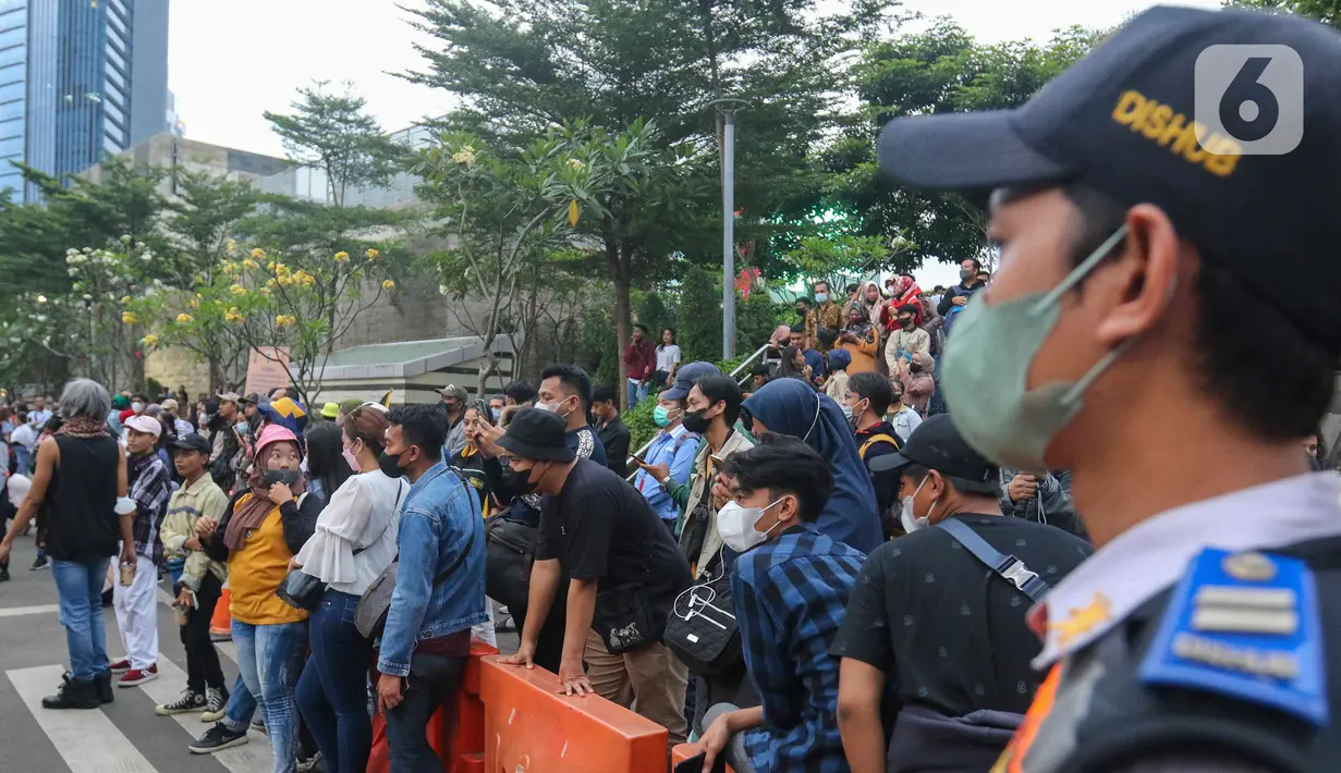 Petugas berjaga saat kegiatan Citayem Fashion Week di Stasiun BNI City, Sudirman, Jakarta Pusat, Senin (25/7/2022). Polres Jakarta Pusat bersama Dishub dan Satpol PP memberhentikan kegiatan cat walk zebra cross Citayam Fashion Week. (Liputan6.com/Herman Zakharia)