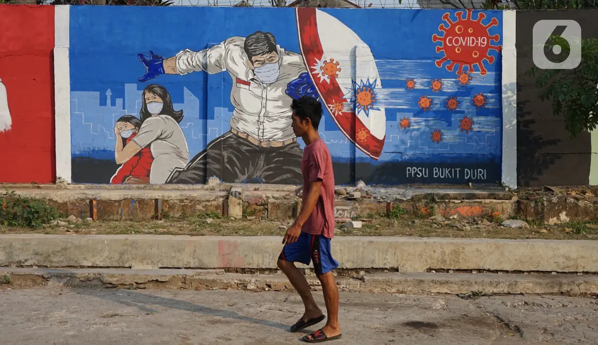 Warga melintas di depan mural bertema covid-19 di Bukit Duri, Jakarta, Minggu (30/8/2020). Mural yang dibuat petugas PPSU bertujuan untuk mengingatkan masyarakat akan bahaya covid-19, sehubungan dengan masih tingginya jumlah kasus positif covid-19 di Jakarta. (Liputan6.com/Immanuel Antonius)