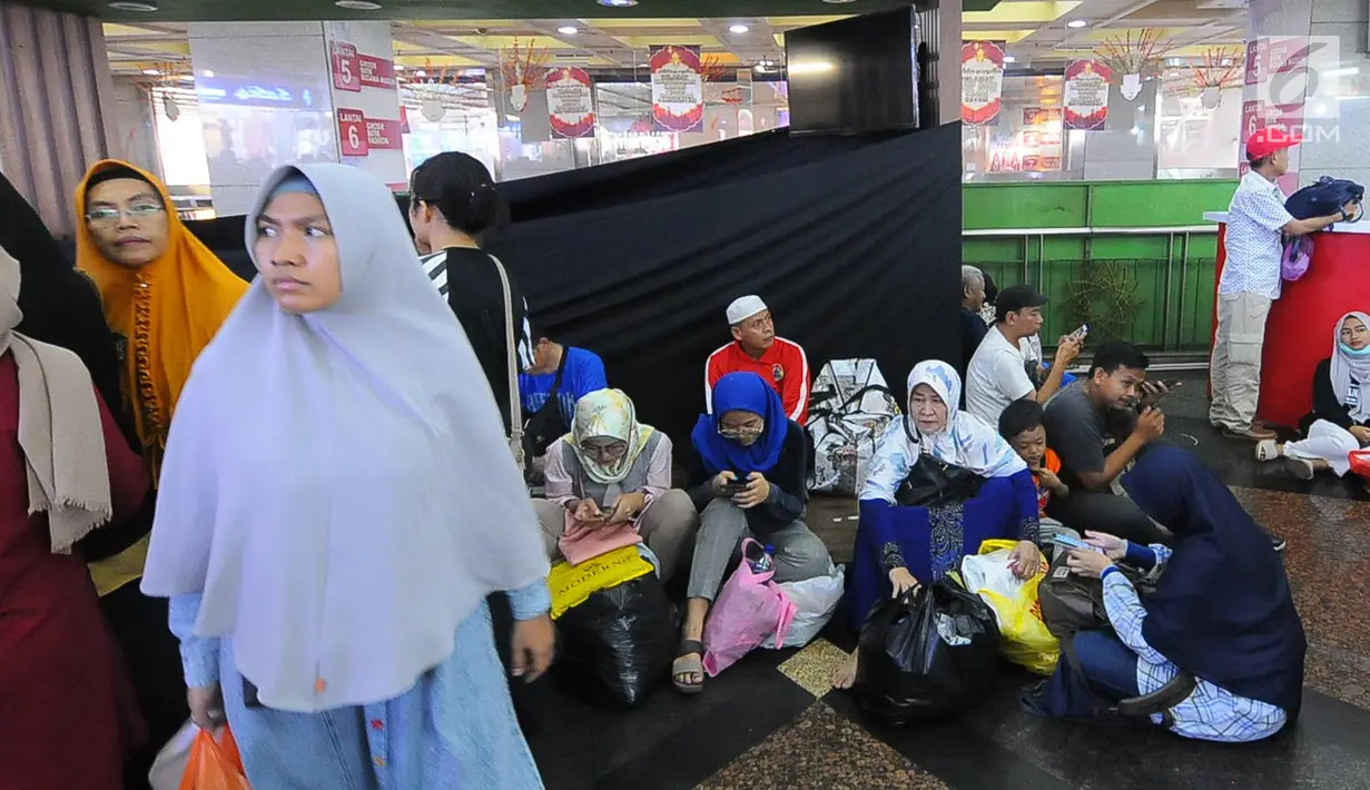Sejumlah warga beristirahat usai berbelanja di pasar Tanah Abang, Jakarta, Minggu (26/5/2019). Jelang lebaran masyarakat mulai memadati pusat perbelanjaan untuk membeli kebutuhan saat Hari Raya Idul Fitri. (Liputan6.com/Angga Yuniar)