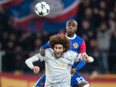 Pemain FC Basel, Eder Balanta melompat merebut bola dari pemain Manchester United, Marouane Fellaini pada matchday kelima Liga Champions di Stadion St Jakob Park, Rabu (22/11). Manchester United takluk 0-1 di markas Basel. (Ennio Leanza/Keystone via AP)