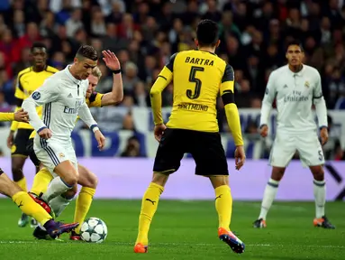 Gelandang Real Madrid, Cristiano Ronaldo berusaha melewati para pemain Borussia Dortmund pada pertandingan Grup F Liga Champions di Santiago Bernabeu, Madrid, (8/12). Real Madrid bermain imbang 2-2 dengan Dortmund. (REUTERS/Susana Vera)