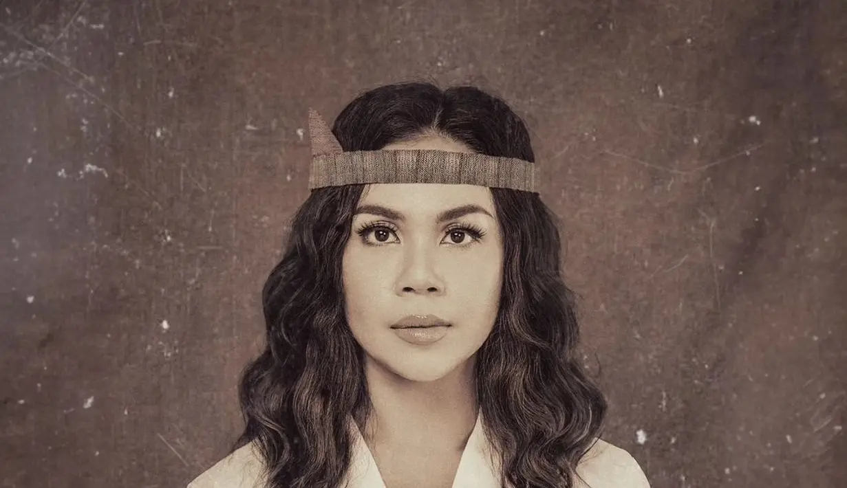 Melaney Ricardo sebagai Kristina Martha Tiahahu mengenakan atasan putih dengan aksesori kepala khas Maluku. [Foto: IG/@yudajulianofficial]