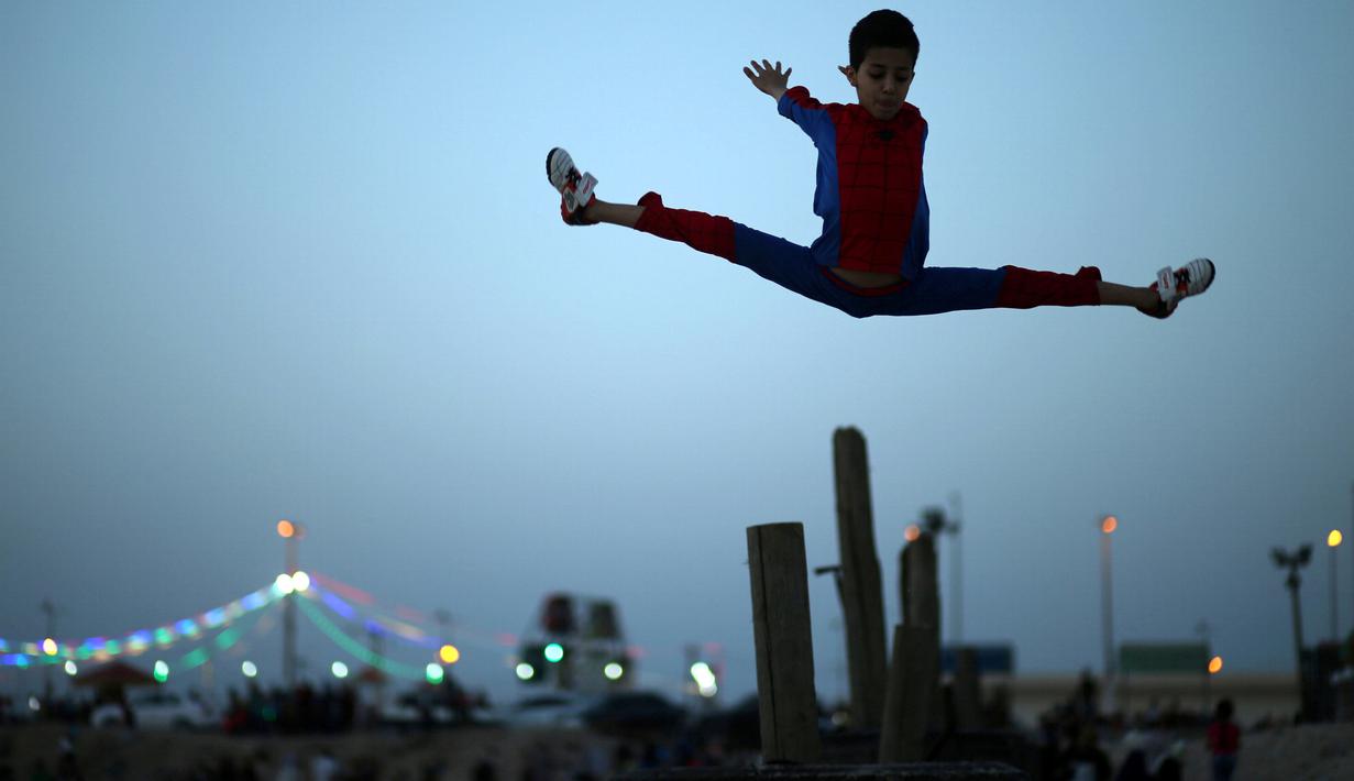 Aksi akrobat Mohammed al Sheikh melompat ke atas, di sebuah pantai di Kota Gaza, Palestina, Kamis (2/6). Remaja 12 tahun itu menyatakan keinginannya untuk mencetak rekor dunia Guinness World Record yang baru. (REUTERS/Mohammed Salem)