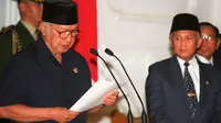 Soeharto didampingi wakilnya, BJ Habibie, membacakan pidato pengunduran dirinya sebagai Presiden RI pada 21 Mei 1998. Soeharto yang telah telah menjadi presiden Indonesia selama 32 tahun mundur setelah runtuhnya dukungan untuk dirinya. (AGUS LOLONG/AFP)