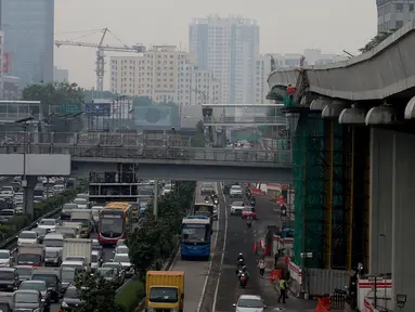 Kendaraan melintas di bawah proyek pembangunan kereta ringan atau Light Rail Transit (LRT) rute Cawang-Dukuh Atas di kawasan Gatot Subroto, Jakarta, Kamis (18/1). (Liputan6.com/JohanTallo)