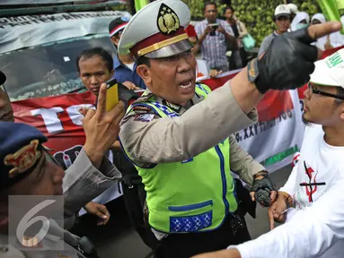 Aparat bersitegang dengan massa aksi dari Front Pancasila saat berusaha masuk menuju Hotel Aryaduta, Jakarta, Senin (18/4). Mereka menolak Simposium PKI yang dapat dimanfaatkan menghidupkan kembali paham komunis. (Liputan6.com/Faizal Fanani)