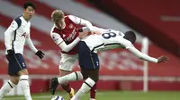 Martin Odegaard dari Arsenal, tengah, dan Tanguy Ndombele dari Tottenham berebut bola selama pertandingan sepak bola Liga Inggris di Stadion Emirates di London, Inggris, Minggu, 14 Maret 2021. (Nick Potts / Pool via AP)