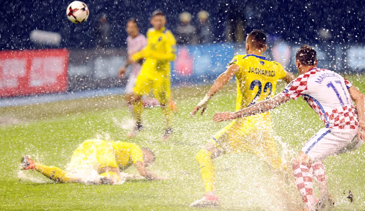 Para pemain Kroasia dan Kosovo berebut bola saat lapangan penuh genangan air pada laga Grup I kualifikasi Piala Dunia 2018 di Stadion Maksimir, Zagreb, (2/9/2017). (AFP/ STR)