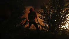 Seorang petugas pemadam kebakaran berusaha memadamkan kebakaran hutan di daerah Rio Maior di Portugal, Rabu (17/8/2022). Pihak berwenang di Portugal mengatakan mereka berharap untuk mengendalikan api yang telah membakar selama 12 hari dan membakar petak besar hutan pinus di Taman Alam Serra da Estrela. (AP Photo/Joao Henriques)