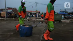 Petugas dari Dinas Lingkungan Hidup DKI Jakarta membawa sampah di Pelabuhan Kali Adem, Muara Angke, Jakarta, Rabu (6/1/2021). Dalam sehari, sampah pesisir Teluk Jakarta Utara bisa terangkut sekitar 7 kubik sampah plastik yang terbawa dari sungai maupun arus laut. (merdeka.com/Imam Buhori)