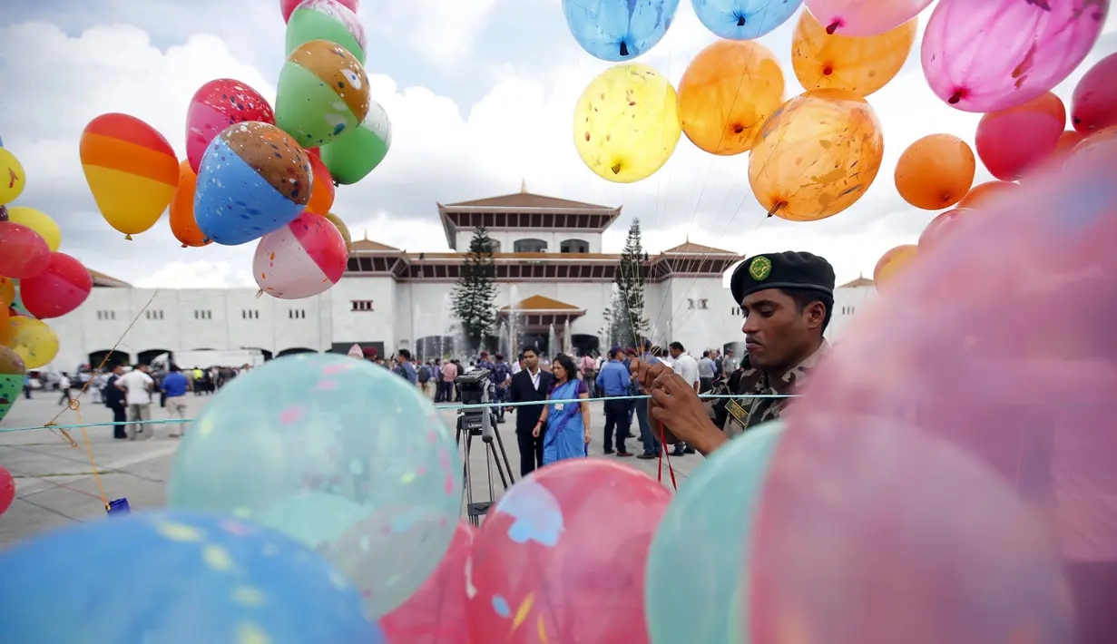 Seorang tentara memasang balon di depan gedung parlemen jelang Presiden Ram Baran Yadav resmi mengesahkan konstitusi baru di Kathmandu, Nepal, Minggu (20/9/2015). Nepal akan mengadopsi piagam demokratis secara penuh. (REUTERS/Navesh Chitrakar)