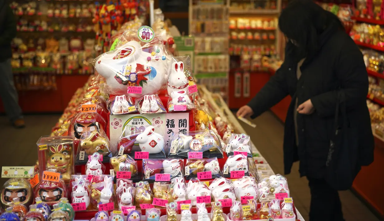 Ornamen Tahun Baru untuk Tahun Kelinci dijual di toko suvenir dekat kuil Kawasaki Daishi, di mana banyak pengunjung berdoa untuk keberuntungan selama "hatsumode" atau kunjungan pertama tahun ini ke kuil atau kuil, di Kawasaki, dekat Tokyo, Senin, 2 Januari 2023. (AP Photo/Eugene Hoshiko )