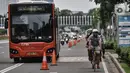 Pesepeda saat melintas di dekat bus Metrotrans di Jalan Jenderal Sudirman, Jakarta, Minggu (1/11/2020). DKI Jakarta meraih penghargaan sebagai Kota Terbaik dunia di bidang inovasi transportasi dalam ajang Sustainable Transport Award (STA) 2021. (merdeka.com/Iqbal S. Nugroho)