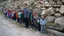 Sejumlah anak berbaris menuju sekolah mereka Desa Atuleer, Tiongkok, Rabu (19/11). Sebelum ada tangga baru, anak-anak harus menempuh perjalanan selama 2 jam menuju ke sekolah yang berada di kaki gunung. (REUTERS)