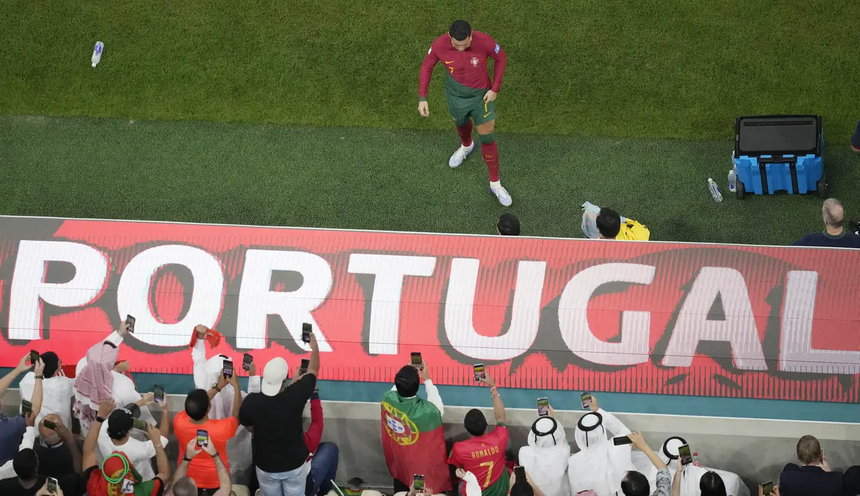 <p>Sejumlah fans memotret penyerang Portugal, Cristiano Ronaldo yang bersiap untuk bermain di lapangan selama pertandingan babak 16 besar Piala Dunia antara Portugal dan Swiss, di Stadion Lusail di Lusail, Qatar, Selasa (6/12/2022). (AP Photo/Thanassis Stavrakis)</p>