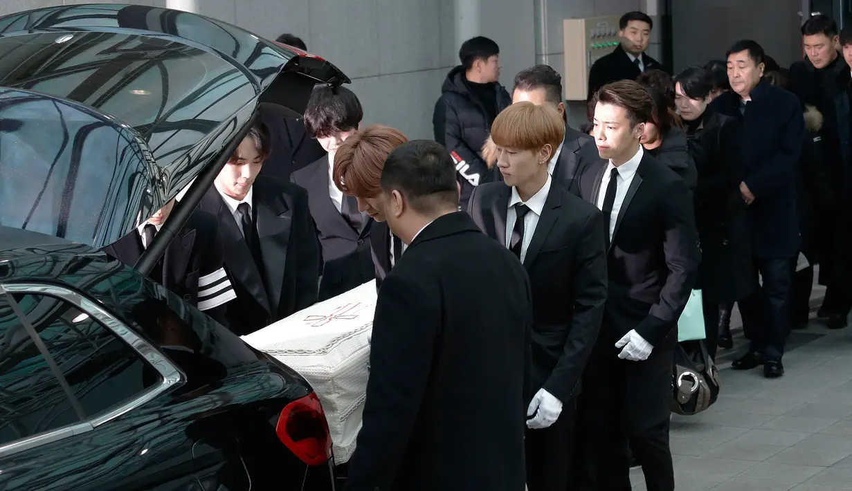 Personel SHINee dan Super Junior memasukkan peti jenazah  Jonghyun SHINee ke dalam mobil menuju tempat pemakaman dari Asan Hospital, Seoul, Kamis (21/12). Prosesi keberangkatan jenazah Jonghyun penuh haru dengan diiringi tangis. (AP/Ahn Young-joon)