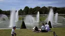 Orang-orang melakukan pendinginan di dekat air mancur taman Trocadero di Paris, Prancis, Rabu (18/5/2022). Cuaca panas diperkirakan akan berlangsung selama beberapa hari di seluruh Prancis. (AP Photo/Christophe Ena)