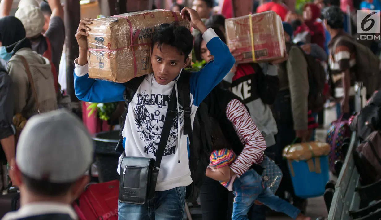 Pemudik membawa barang miliknya di Stasiun Senen, Jakarta, Senin (19/6). Pada hari ini telah tercatat sebanyak 25.265 pemudik yang akan naik dari Stasiun Pasar Senen dan diperkirakan akan bertambah. (Liputan6.com/Gempur M Surya)