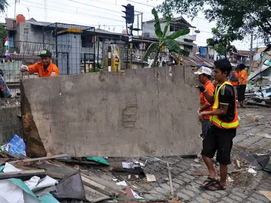 Petugas dari dinas pekerjaan umum membongkar puluhan bangunan liar di dekat stasiun Tebet, Jakarta, Selasa (19/8/14). (Liputan6.com/Miftahul Hayat)