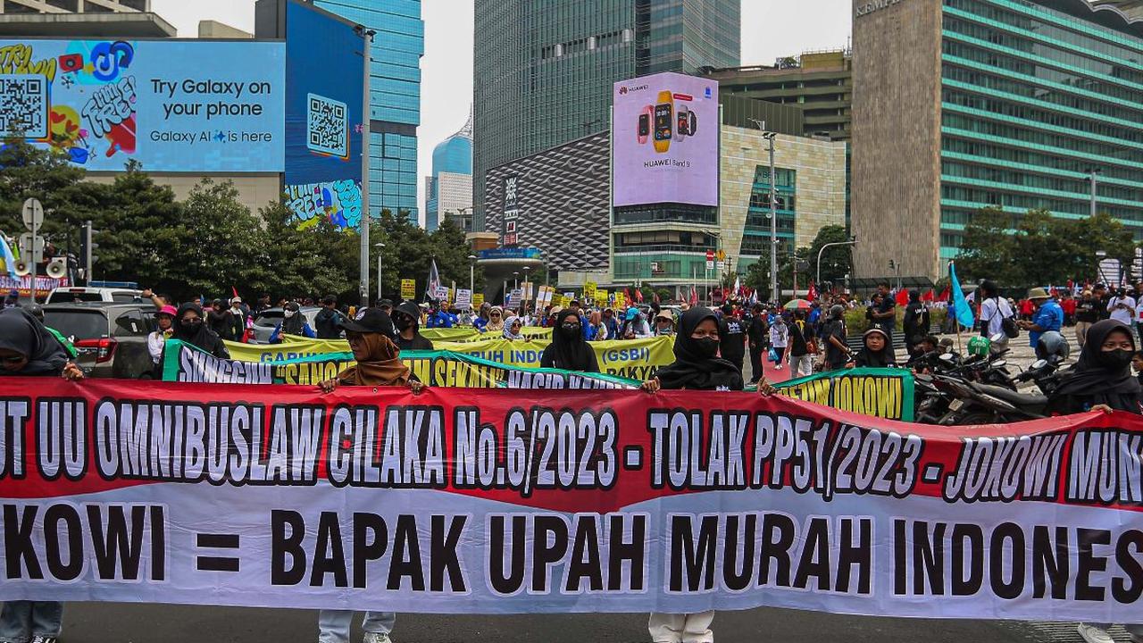Selain itu, dalam salah satu spanduk yang terpampang, massa buruh menuliskan "Jokowi= Bapak Upah Murah Indonesia".