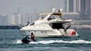 Sebuah kapal pesiar mewah digambarkan dari Dubai Marina Beach di emirat Teluk, 10 Juni 2021. Di tengah aturan pandemi di mana warga harus menjaga jarak dan menghindari keramaian, orang-orang kaya di Dubai memiliki cara untuk bisa pergi berekreasi, yaitu mode wisata kapal pesiar. (Karim SAHIB/AFP)