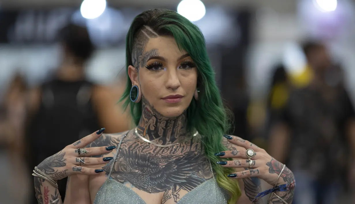 Seorang wanita berpose memamerkan tato pada tubuhnya dalam acara Sao Paulo Tattoo Week, Brasil, Jumat (25/10/2019). (AP Photo/Andre Penner)