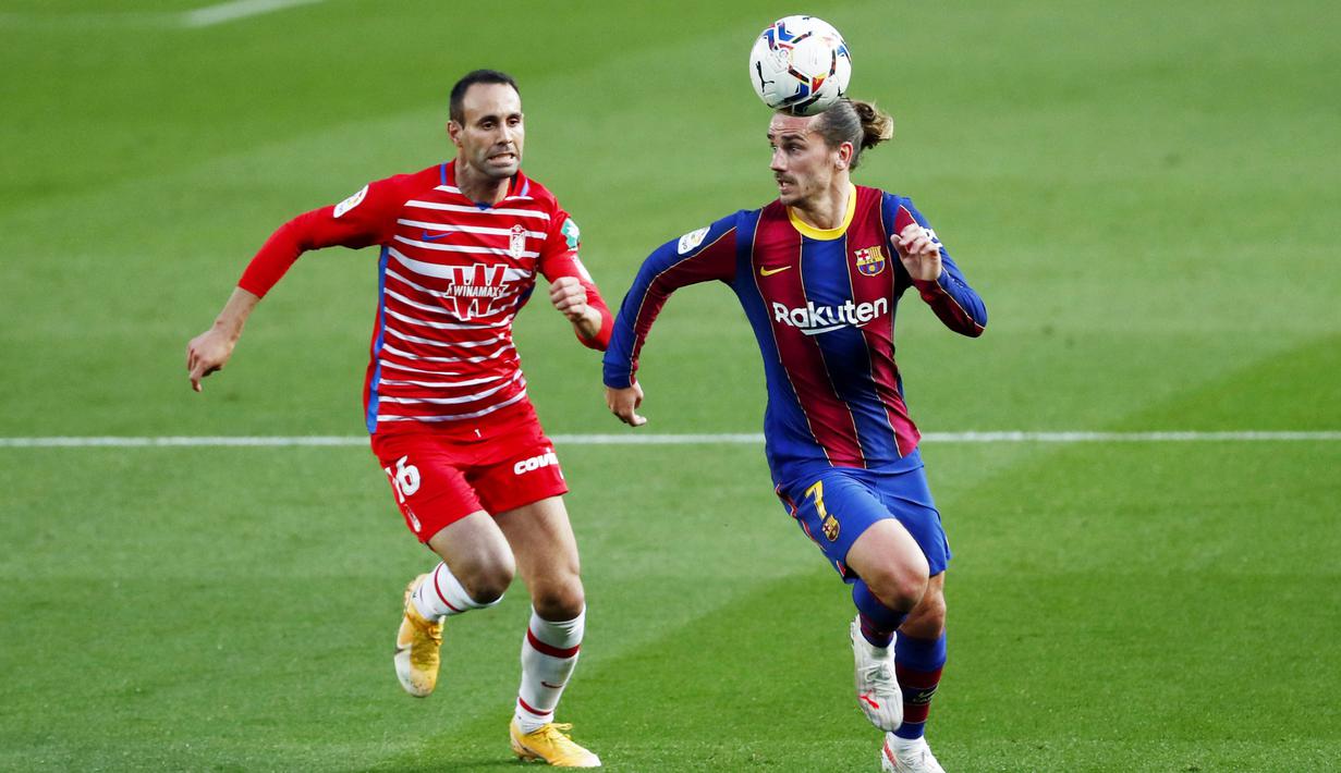 Penyerang Barcelona, Antoine Griezmann, berebut bola dengan pemain Granada, Victor Diaz, pada laga Liga Spanyol di Stadion Camp Nou, Jumat (30/4/2021). Barcelona takluk dengan skor 1-2. (AP/Joan Monfort)